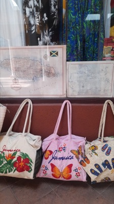 Jamaica-branded beach tote bags in front of island map artwork