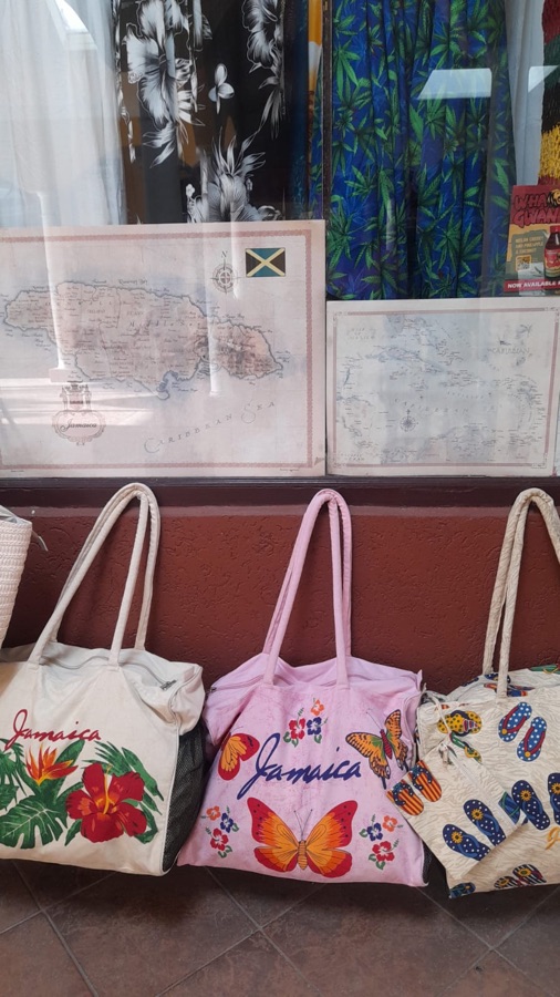 Jamaica-branded beach tote bags in front of island map artwork