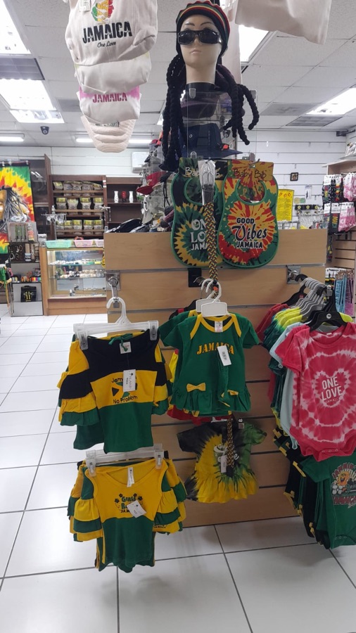 Children's Rasta-themed t-shirts and outfits on a clothing rack